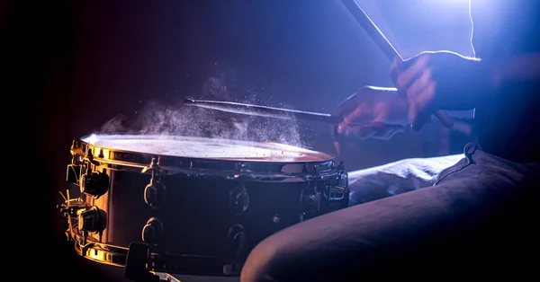 Hombre tocando el tambor de la trampa sobre un hermoso fondo de color — Foto de Stock