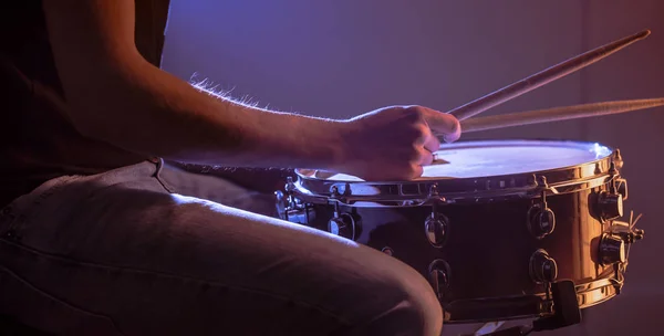 Man playing the snare drum on a beautiful colored background — Stockfoto