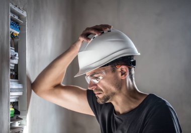 Elektrik santralinde fitili olan bir elektrik teknisyeni.