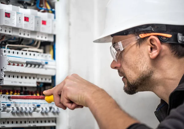 Hombre, un técnico eléctrico trabajando en una centralita con fusible — Foto de Stock