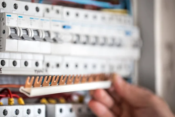 Hombre, un técnico eléctrico trabajando en una centralita con fusible — Foto de Stock