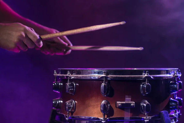 The drummer plays the drums. Beautiful blue and red background, — Stockfoto