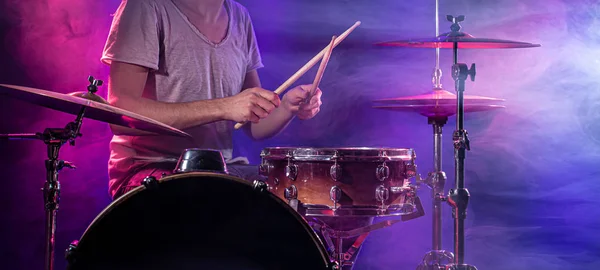 The drummer plays the drums. Beautiful blue and red background, — Stockfoto