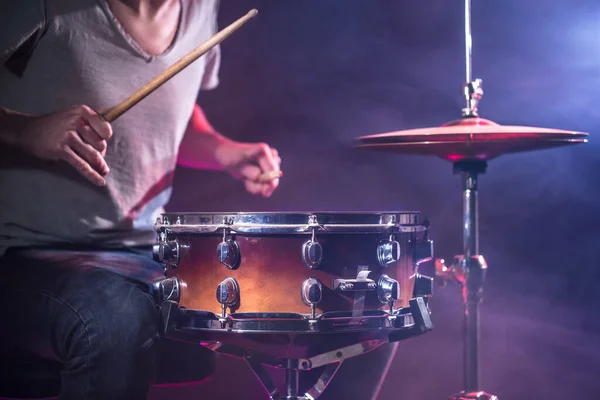 El baterista toca la batería. Hermoso fondo azul y rojo , — Foto de Stock