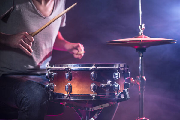 The drummer plays the drums. Beautiful blue and red background, 