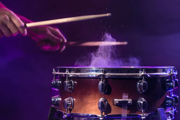 The drummer plays the drums. Beautiful blue and red background, — Stockfoto