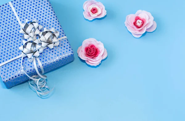 Подарункова коробка упакована в синій папір на синьому фоні  . — стокове фото