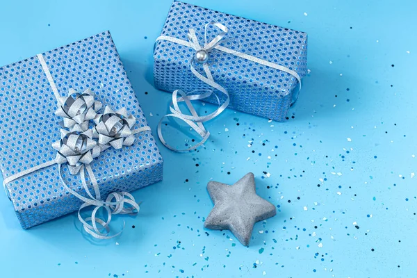 Подарункова коробка упакована в синій папір на синьому фоні  . — стокове фото