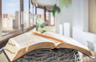 Book Bible with pencil close-up, on the background of a beautifu