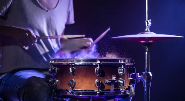 Барабанщик играет на барабанах на синем фоне. Особые приметы — стоковое фото