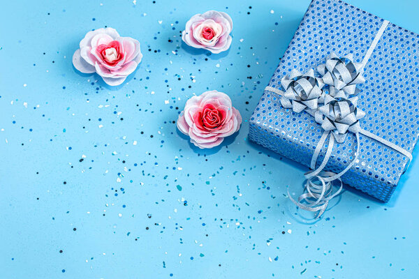 Gift box Packed in blue paper on a blue background .