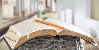 Book Bible with pencil close-up, on the background of a beautifu