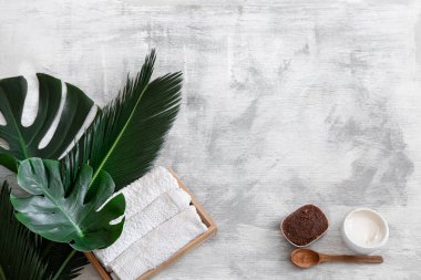 Spa mı? Beyaz arka planda tropikal yapraklı vücut bakımı ögeleri.