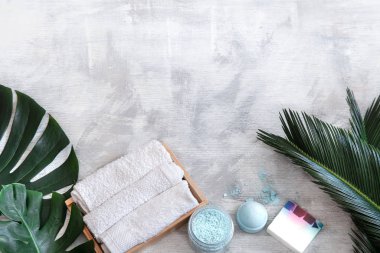 Spa mı? Beyaz arka planda tropikal yapraklı vücut bakımı ögeleri.