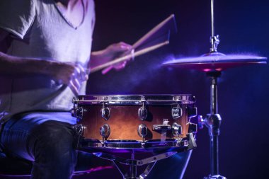 Bir davulcu mavi arka planda davul çalar. Güzel özel at