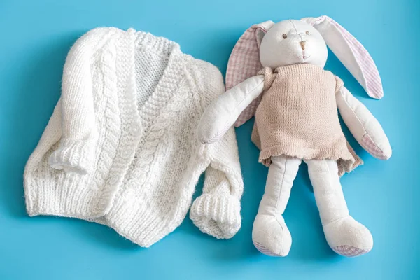 Gestrickte Babybekleidung und Accessoires auf blauem Hintergrund . — Stockfoto