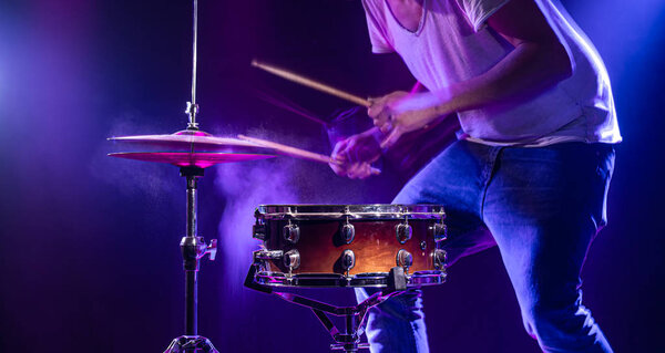 Барабанщик играет на барабанах на синем фоне. Особые приметы
