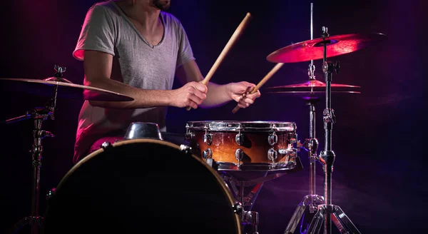 El baterista toca la batería. Hermoso fondo azul y rojo , — Foto de Stock