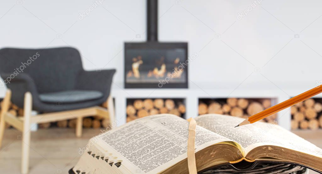 A man holding a Bible with a pencil, against the background of t