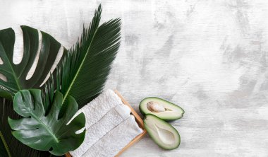 Spa mı? Beyaz arka planda tropikal yapraklı vücut bakımı ögeleri.