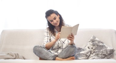 kadın kanepede kitap okuma.