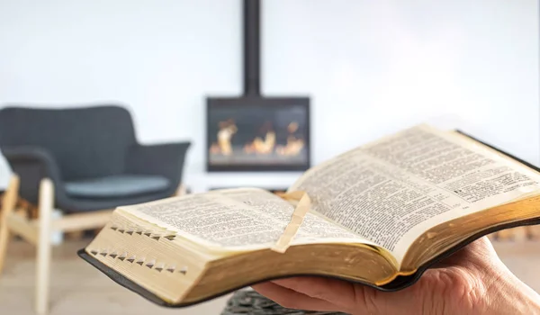 Un hombre tiene una Biblia en sus manos, en el fondo de la — Foto de Stock