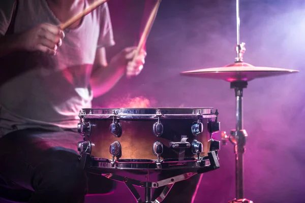 Der Schlagzeuger spielt Schlagzeug. schöner blauer und roter Hintergrund, — Stockfoto