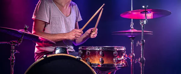 The drummer plays the drums. Beautiful blue and red background, — Stock Photo, Image