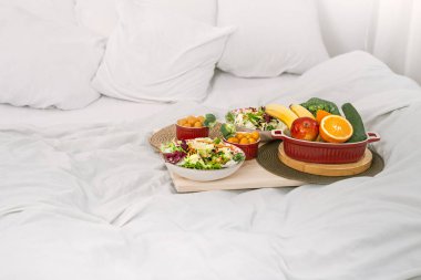 Sağlıklı sağlıklı kahvaltı ve yatakta meyve.