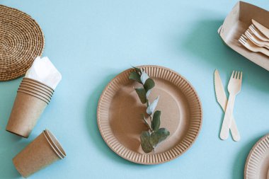 Çevre dostu, şık geri dönüşümlü kağıt sofra takımı. Nane ve mavi arka planda kağıt yiyecek kutuları, tabaklar ve mısır nişastası. .