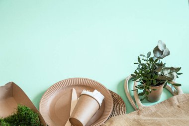 Çevre dostu, şık geri dönüşümlü kağıt sofra takımı. Nane ve mavi arka planda kağıt yiyecek kutuları, tabaklar ve mısır nişastası. .