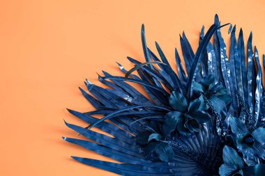 Çiçeğin arkaplanı turuncu ve mavi renkli yapay çiçeklerdir. Mesaj için yer var. Eğilim rengi.