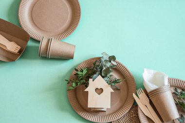 Çevre dostu, şık geri dönüşümlü kağıt sofra takımı. Nane ve mavi arka planda kağıt yiyecek kutuları, tabaklar ve mısır nişastası. .
