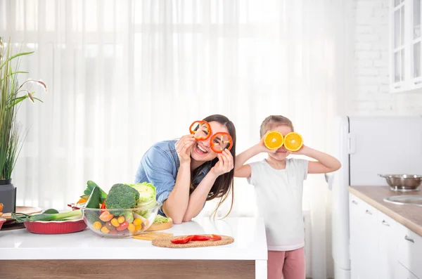 Healthy food at home. Happy family in the kitchen. Mother and child daughter are preparing the vegetables and fruit.Vegan food