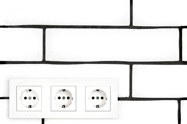 电源插座靠在白色的砖墙上 案文的篇幅 — 图库照片