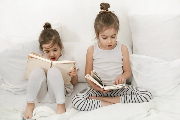 Zwei Süße Kleine Schwestermädchen Lesen Ein Buch Auf Dem Bett — Stockfoto