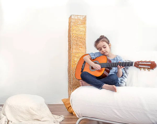Una Niña Sienta Sofá Toca Guitarra Concepto Desarrollo Valores Infantiles — Foto de Stock