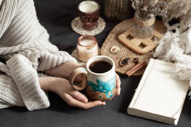 Güzel bir kupa ve kadın eli ile sakin bir hayat. Samimi, sade bir atmosfer. dekoratif ögeler.