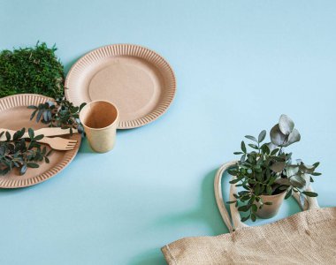 Çevre dostu, şık geri dönüşümlü kağıt sofra takımı. Nane ve mavi arka planda kağıt yiyecek kutuları, tabaklar ve mısır nişastası. .