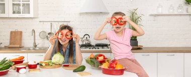 Anne ve kızı mutfakta bir salata hazırlayın. İyi eğlenceler ve sebzelerle oynayın. Sağlıklı beslenme ve yaşam tarzı kavramı. Vejetaryen beslenme ve sağlıklı bir yaşam tarzı..