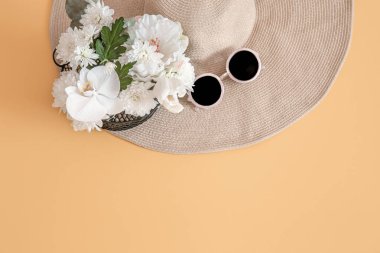 Yaz aksesuarları, hasır şapka, çanta ve gözlük. Yaz modası ve seyahat malzemeleri. Turuncu renkli arka plan. Yaz konsepti.