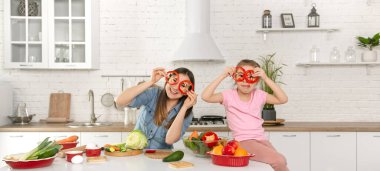 Anne ve kızı mutfakta bir salata hazırlayın. İyi eğlenceler ve sebzelerle oynayın. Sağlıklı beslenme ve yaşam tarzı kavramı. Vejetaryen beslenme ve sağlıklı bir yaşam tarzı..
