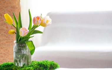 Anneler Günün kutlu olsun. Beyaz arka planda harfler. Anneler günü için ahşap bir yazı oturma odasındaki ahşap bir masa üzerinde taze, güzel bir buket bahar lalesi..