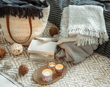 Evin iç kısımlarında dekoratif eşyalar. Hasır saman büyük çanta ve dekoratif elementler. Tarz ve konfor kavramları.