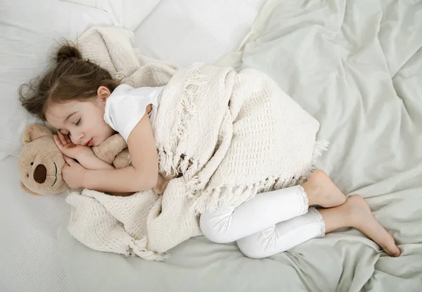 Sevimli Küçük Bir Kız Oyuncak Bir Ayıyla Yatakta Uyuyor Çocuk — Stok fotoğraf