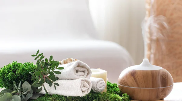 温泉配料 带有现代油散发筒的香气 并配以护身产品 白色的毛巾 春绿的花 身体和保健的温泉概念 — 图库照片