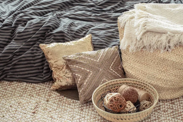 Decorative items in a cozy home interior. Wicker straw large bag, and decorative elements. Concepts of style and comfort.