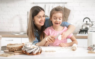 Mutlu bir aile. Anne ve kızı mutfakta hamur işleri hazırlıyorlar. Sevgi dolu aile ve aile değerleri kavramı. Sağlıklı ev yemekleri..