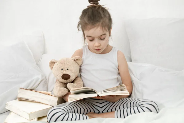 Nettes Kleines Mädchen Liest Ein Buch Auf Dem Bett Schlafzimmer — Stockfoto