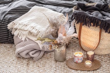 Evin iç kısımlarında dekoratif eşyalar. Hasır saman büyük çanta ve dekoratif elementler. Tarz ve konfor kavramları.